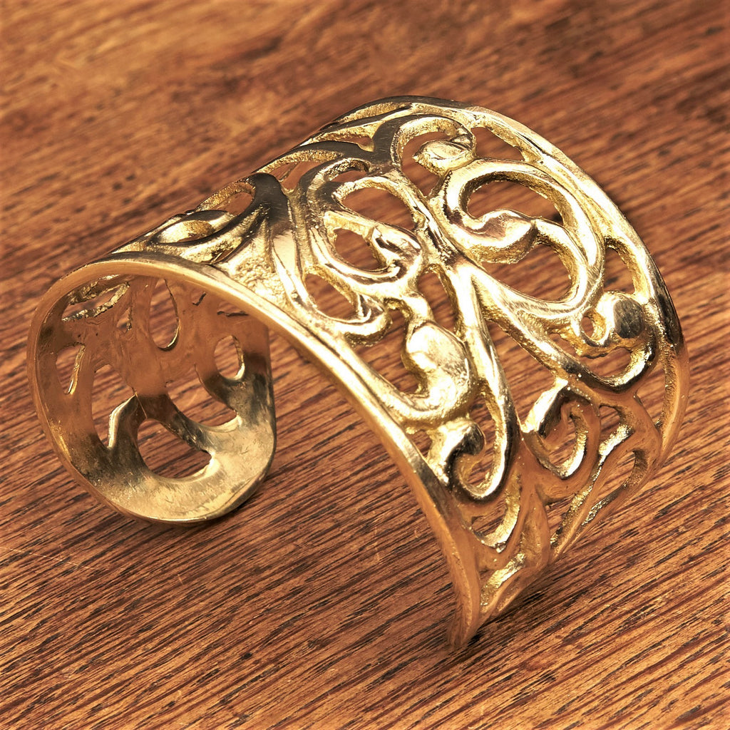 An artisan handmade, chunky pure brass open floral patterned wide cuff designed by OMishka.