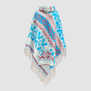Colorful blue patterned poncho with fringes on a light gray background