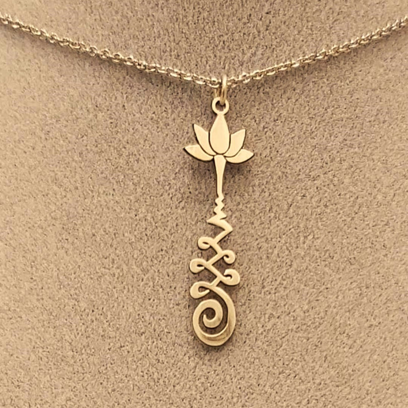 Brass necklace with a lotus flower and a Unalome design.