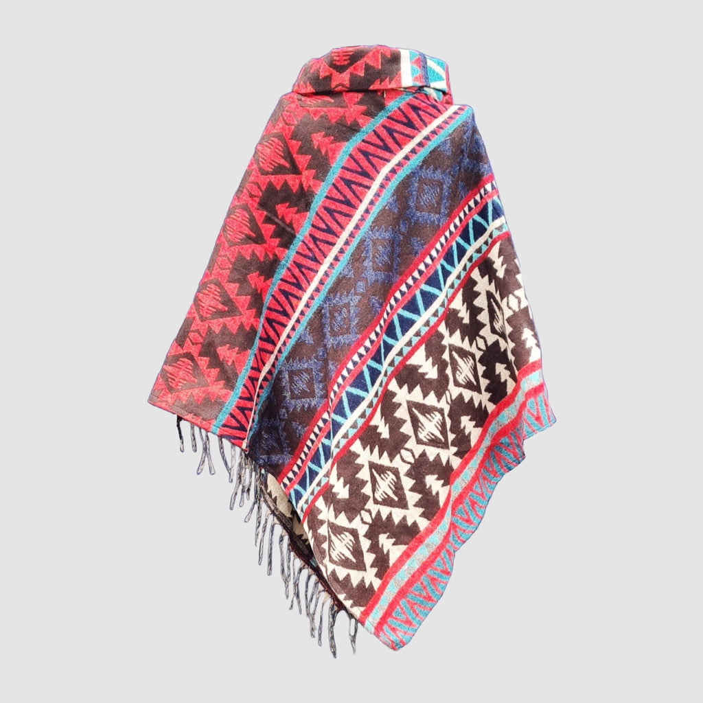 Colorful black and red patterned poncho with fringes on a light gray background