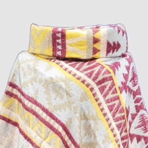 Colorful patterned cowl neck poncho with an Aztec design on a light gray background