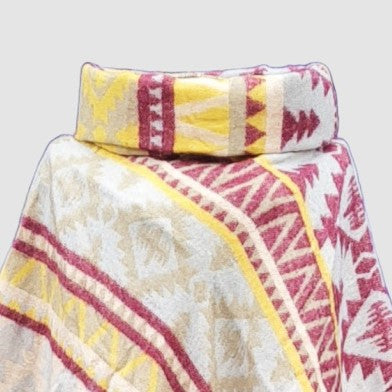 Colorful patterned cowl neck poncho with an Aztec design on a light gray background