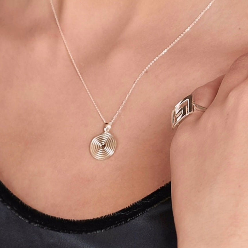 Small silver spiral pendant on a silver chain.