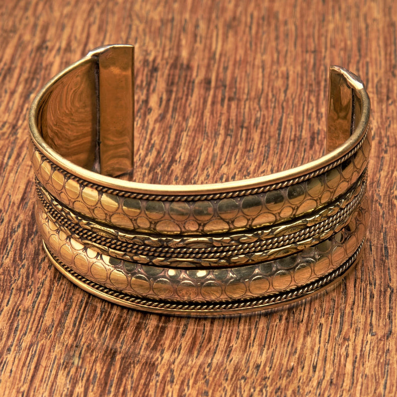 An adjustable pure brass, spotty patterned and coiled striped cuff bracelet designed by OMishka.