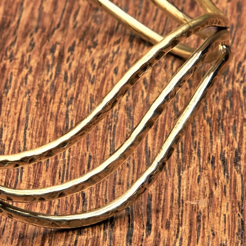 An adjustable, hammered pure brass triple wave cuff bracelet designed by OMishka.