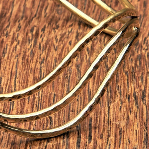 An adjustable, hammered pure brass triple wave cuff bracelet designed by OMishka.