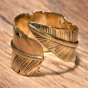 An adjustable, handmade pure brass, feather wrap ring designed by OMishka.