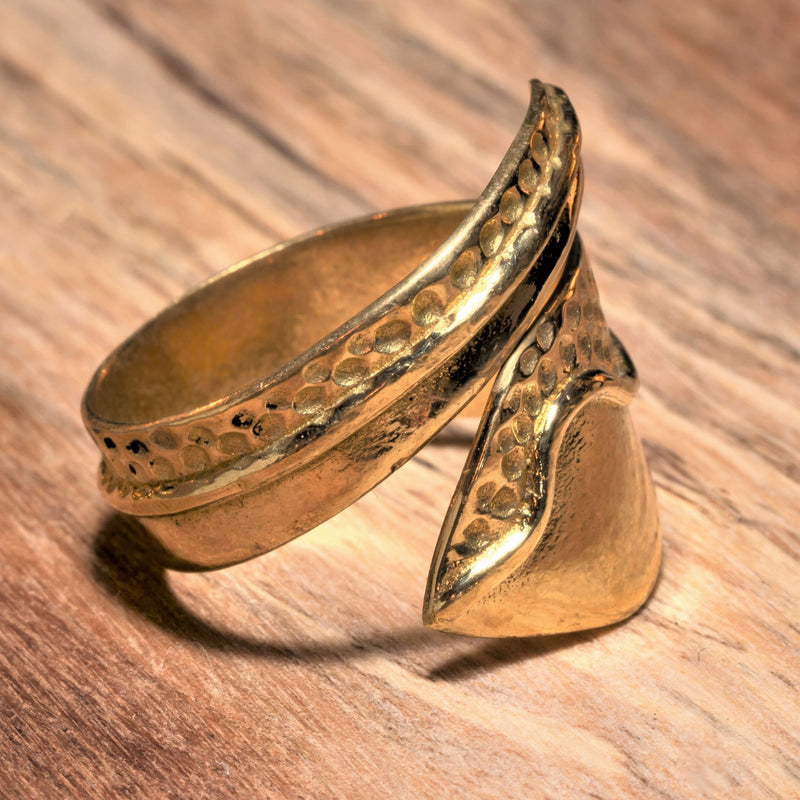 An adjustable, handmade smooth pure brass, dot patterned wrap ring designed by OMishka.