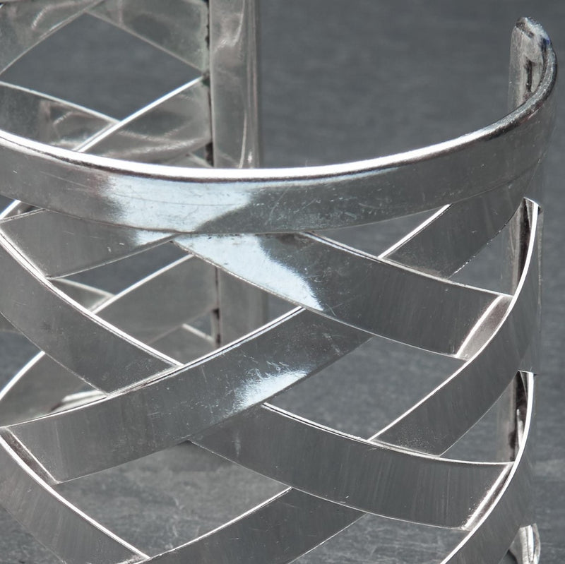 An adjustable, open lattice weave detailed silver wide cuff bracelet designed by OMishka.
