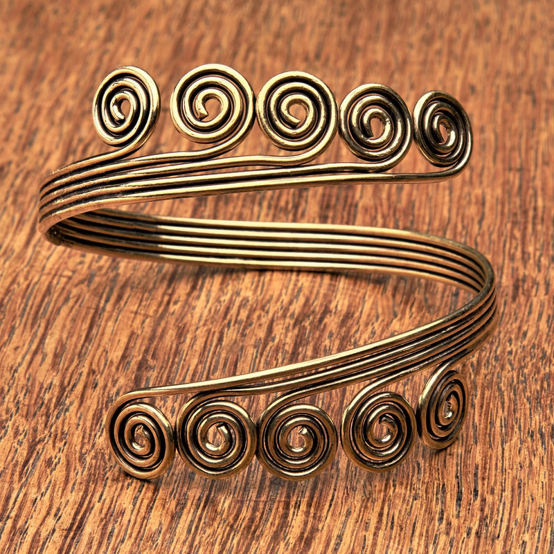 An adjustable, open spiral pure brass arm cuff bracelet designed by OMishka.