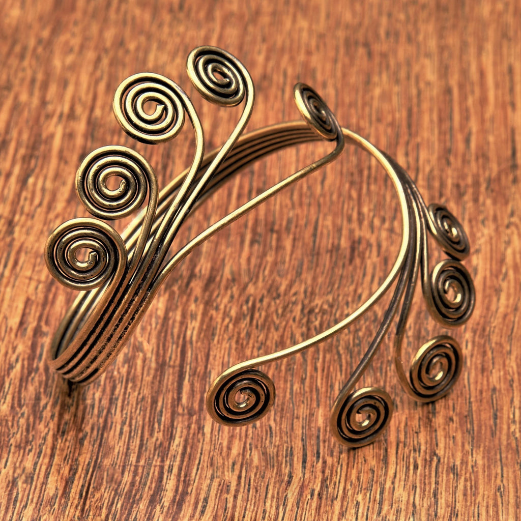 An adjustable, open spiral pure brass armlet designed by OMishka.
