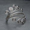 An adjustable, open spiral silver arm cuff bracelet designed by OMishka.