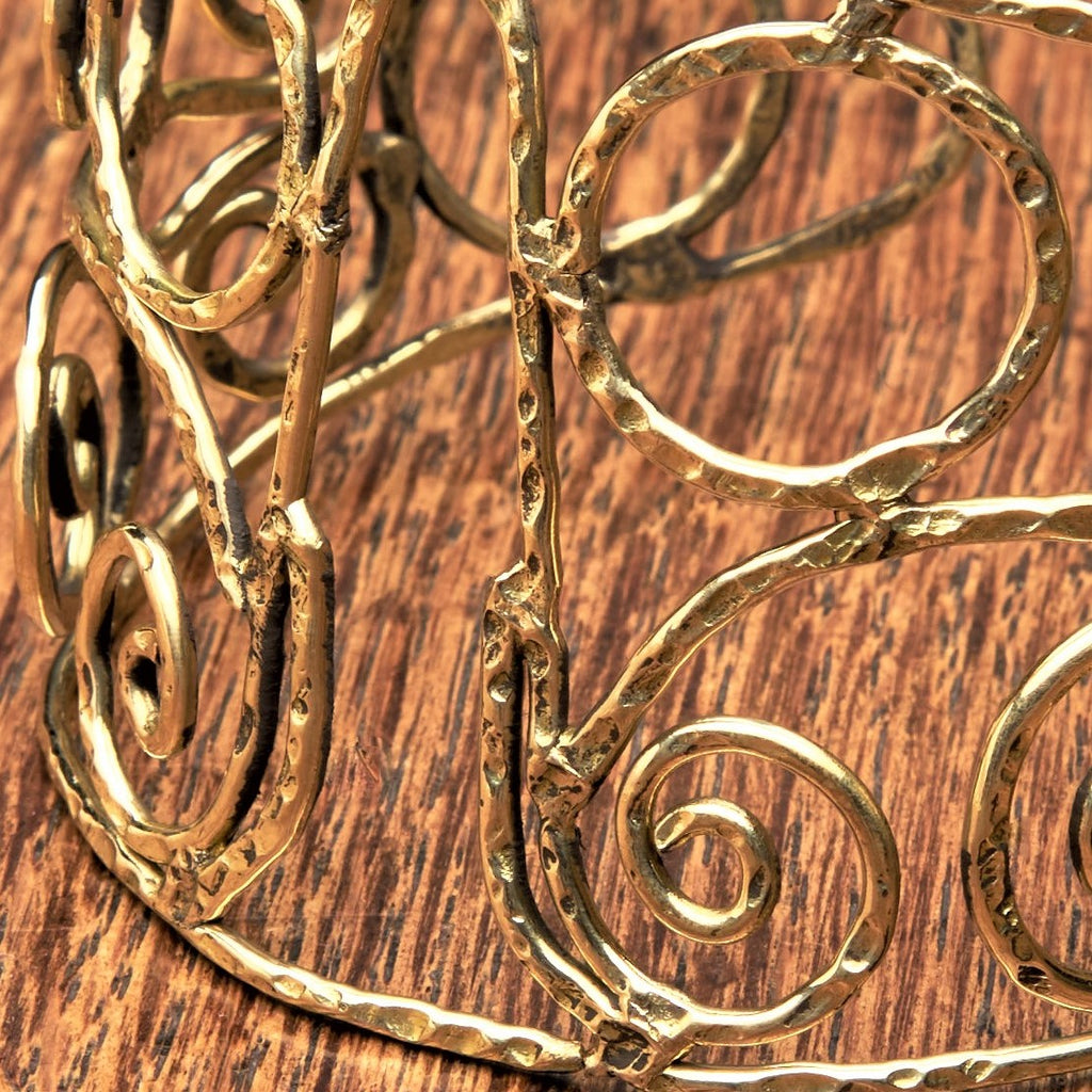 An adjustable wide, pure brass spiral patterned open bracelet designed by OMishka.