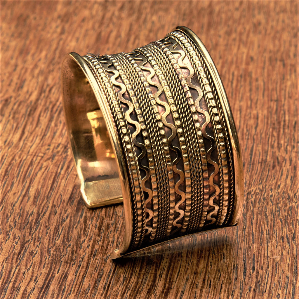An adjustable, wide concave shaped pure brass wavy patterned cuff bracelet designed by OMishka.
