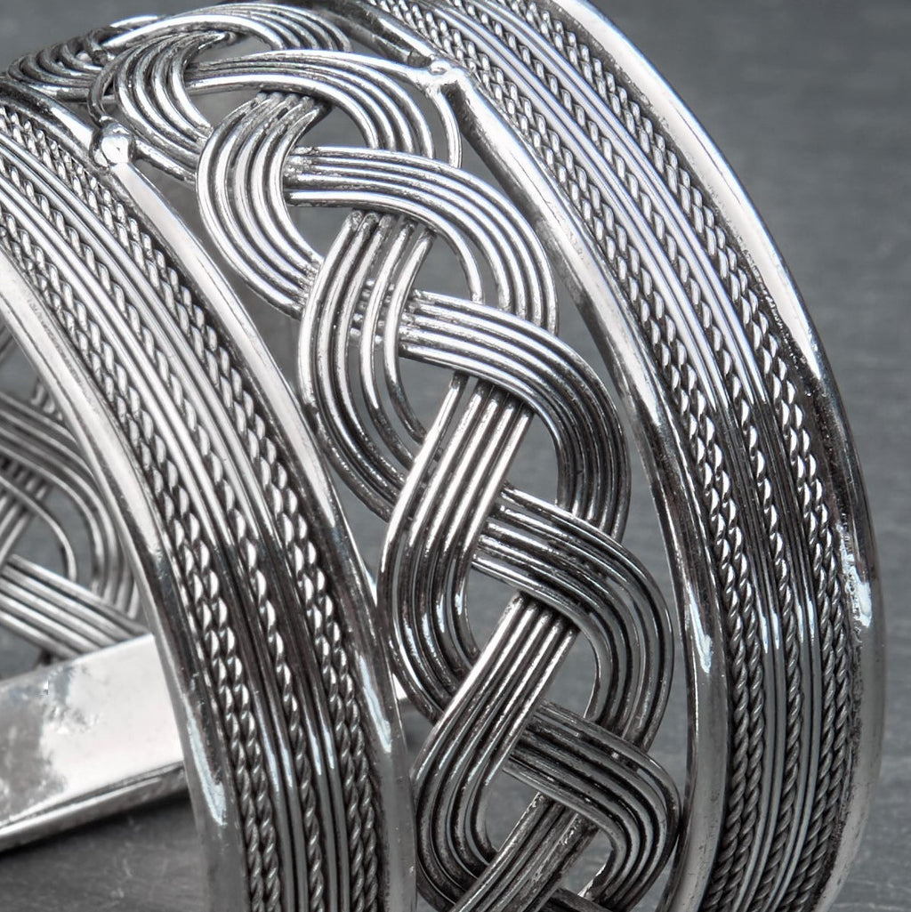 An adjustable. wide woven patterned silver open cuff bracelet designed by OMishka.