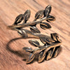 An adjustable, artisan handmade pure brass olive branch wrap ring designed by OMishka.