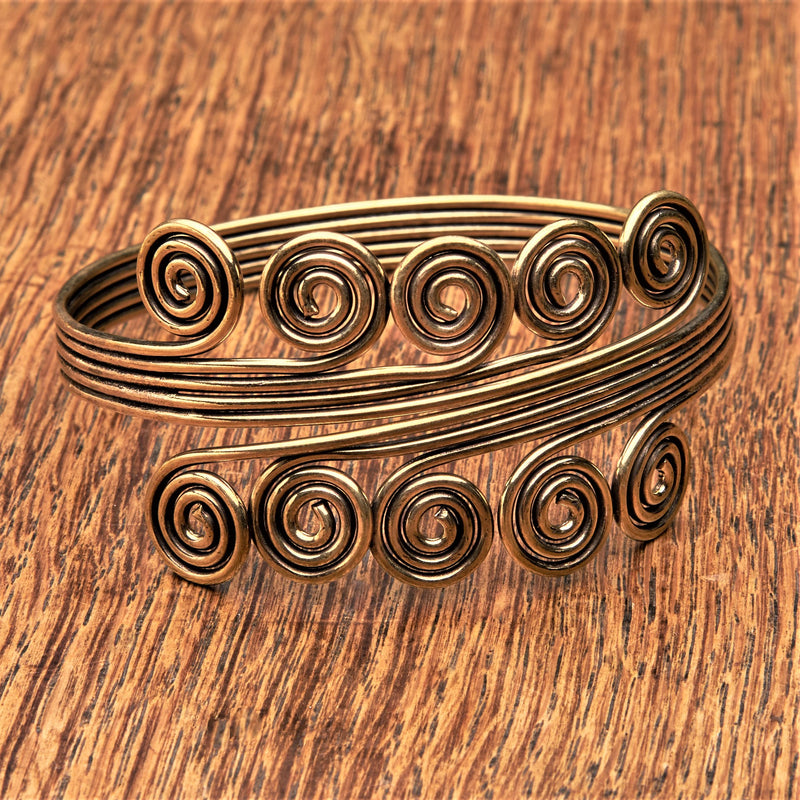 An artisan handmade pure brass, open spiral armlet designed by OMishka.