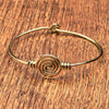 An artisan handmade, pure brass spiral patterned bangle bracelet designed by OMishka.