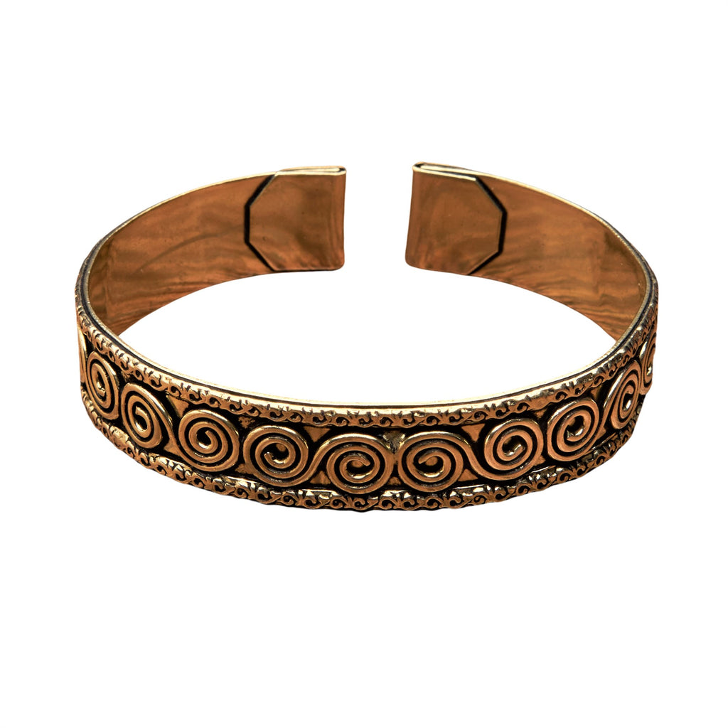 An artisan handmade, pure brass spiral patterned torque bracelet designed by OMishka.