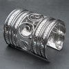 An artisan handmade, extra wide silver open spiral patterned cuff bracelet designed by OMishka.