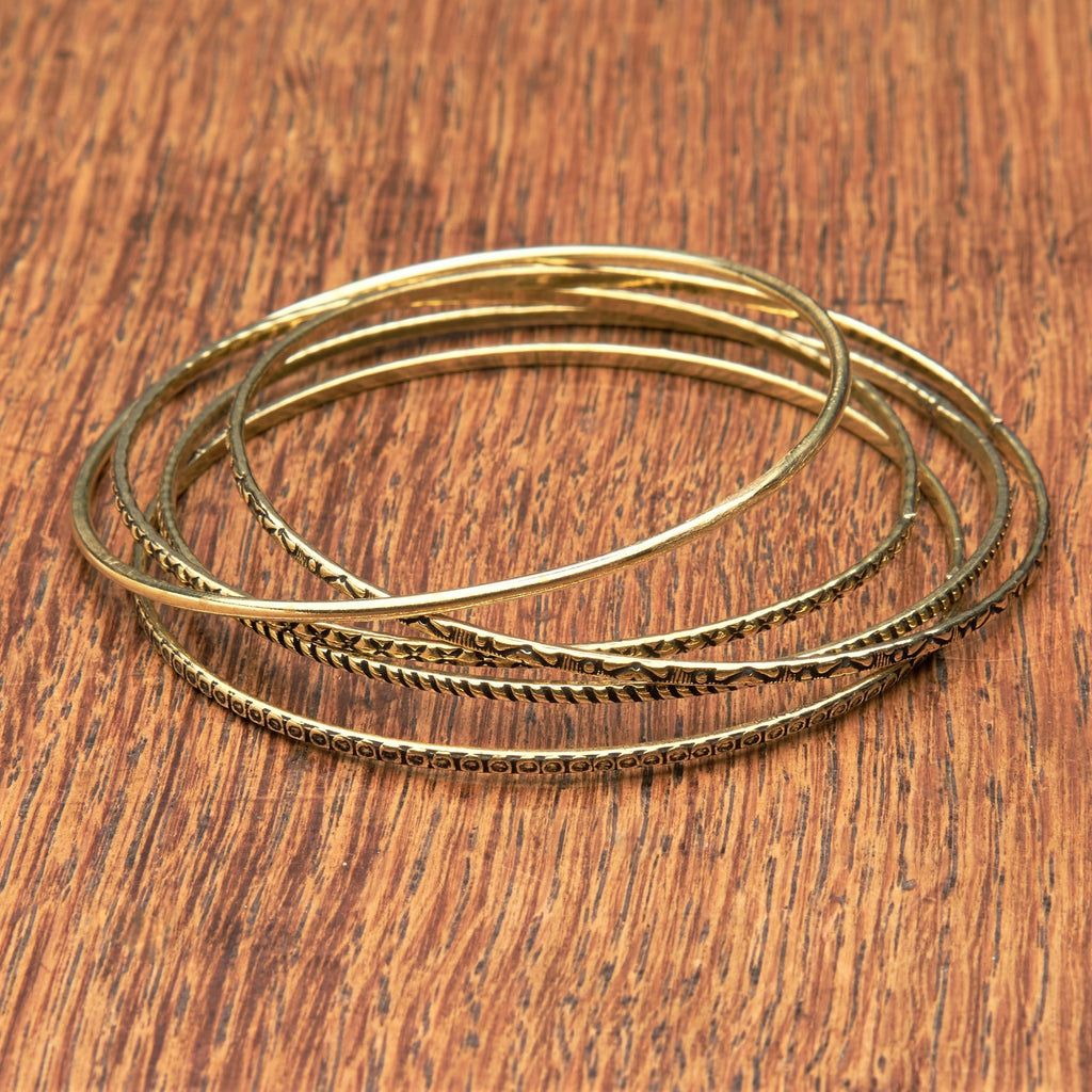 An artisan handmade, pure brass set of 5 bangles each etched with traditional Indian patterns designed by OMishka.