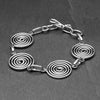 Artisan handmade silver toned brass, 4 simple infinity spirals, chain linked bracelet designed by OMishka.