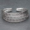 An artisan handmade silver, multi stacked cuff bracelet designed by OMishka.