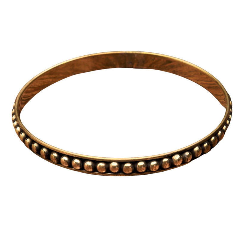 An artisan handmade, thin, dot beaded pure brass bangle bracelet designed by OMishka.