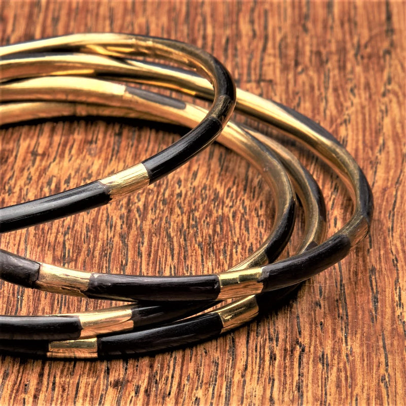 An artisan handmade, set of 4 pure brass and black enamel striped thin bangle bracelets designed by OMishka.