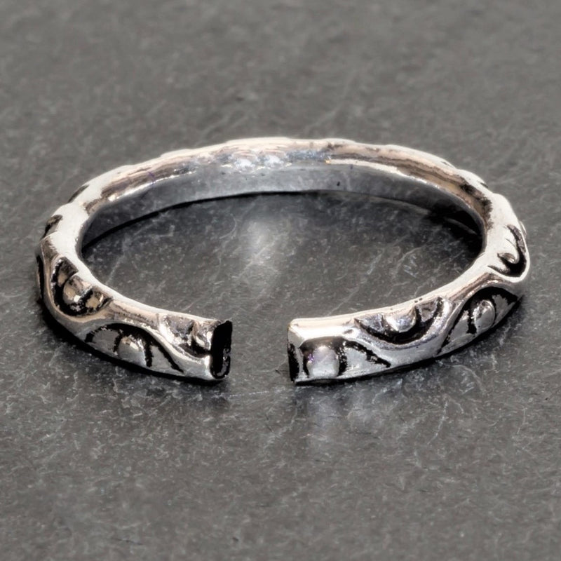 An adjustable, dainty solid silver dotted and swirl patterned band toe ring designed by OMishka.