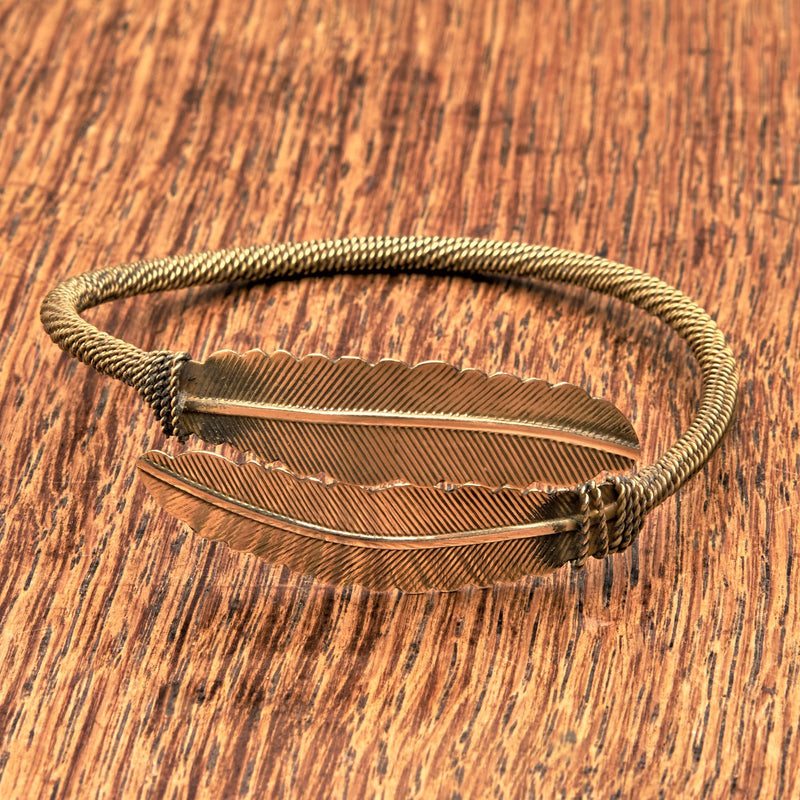 A double feather, pure brass wrap bracelet designed by OMishka.