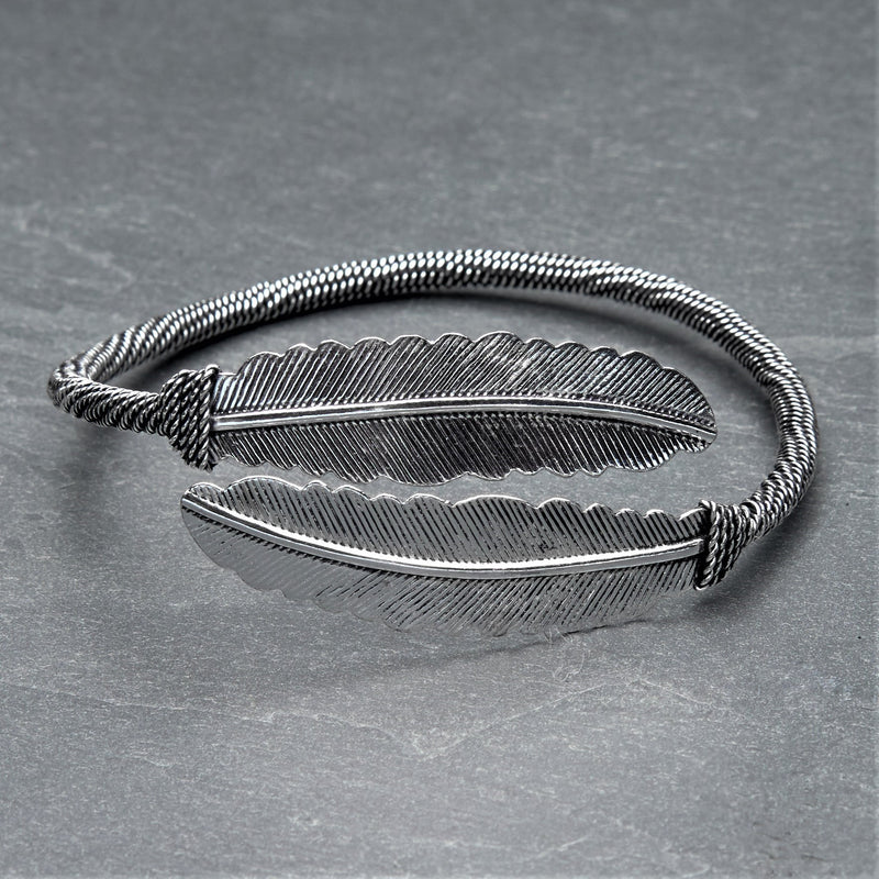 A double feather, silver wrap torque bracelet designed by OMishka.
