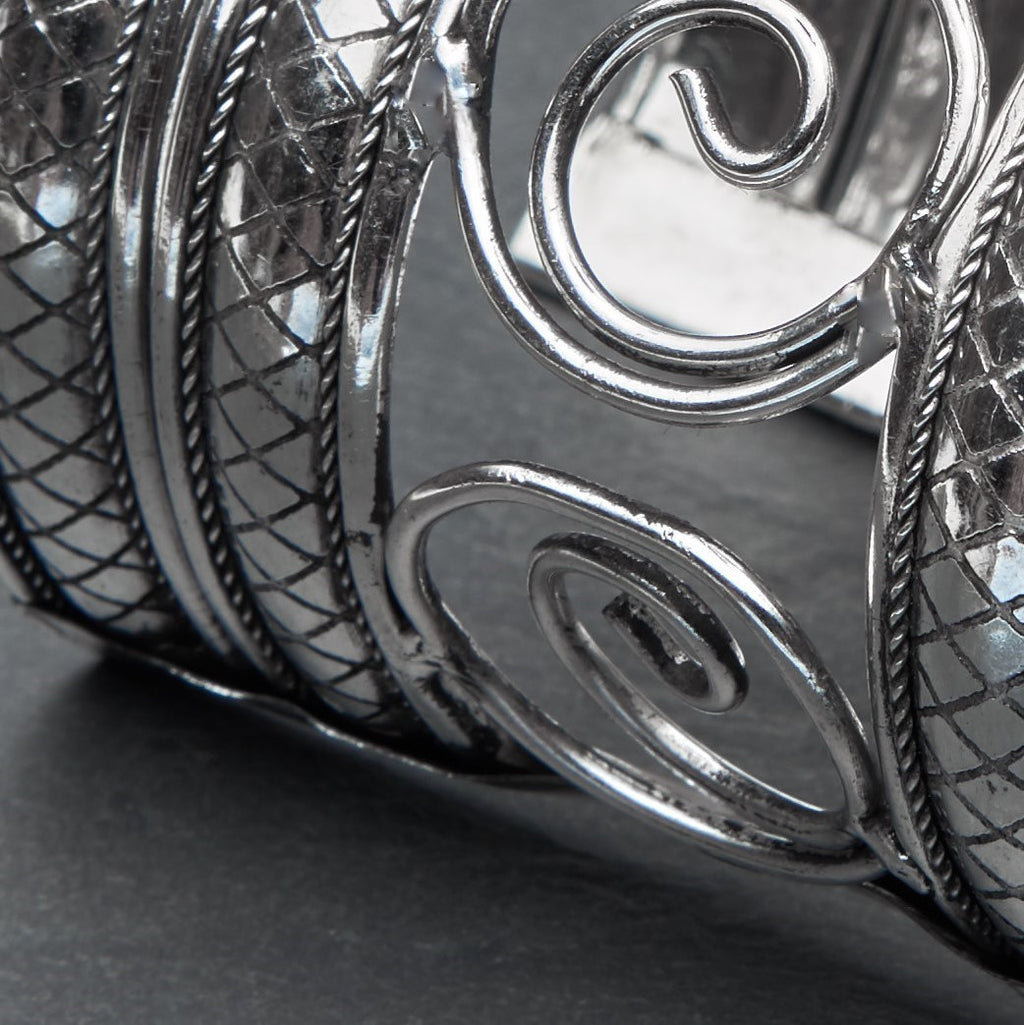 An extra wide adjustable, silver open spiral patterned cuff bracelet designed by OMishka.