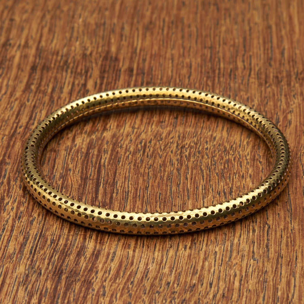 A handmade, light, dotted pure brass bangle bracelet designed by OMishka.
