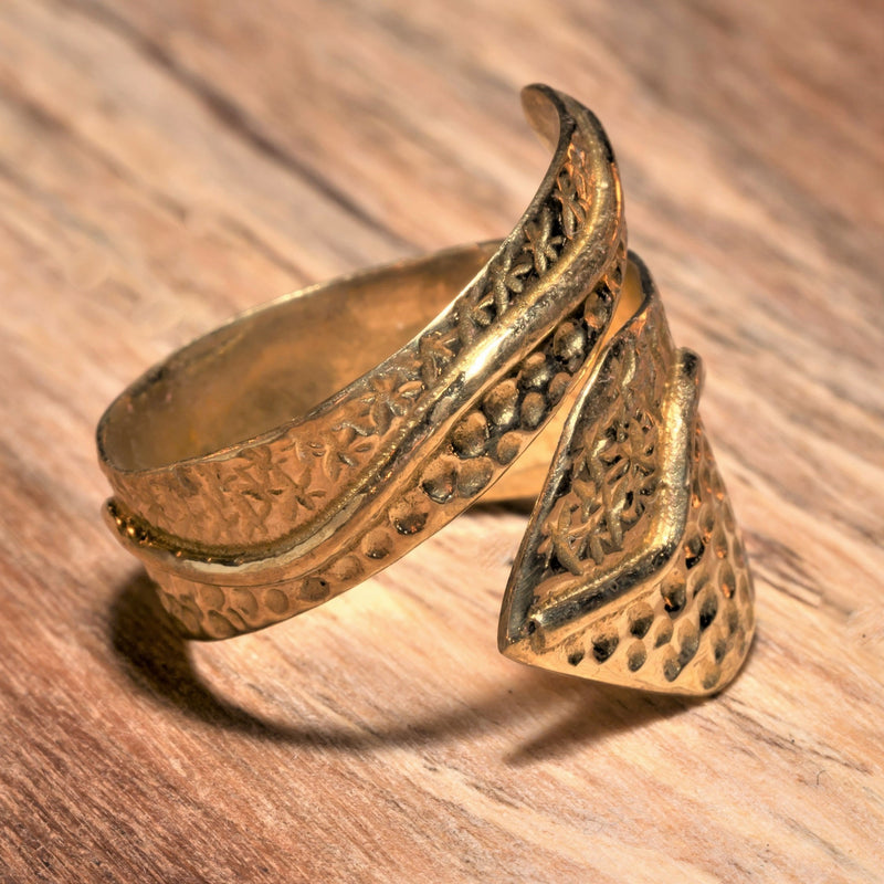 An adjustable, chunky, handmade pure brass, dotted, star and swirl patterned wrap ring designed by OMishka.