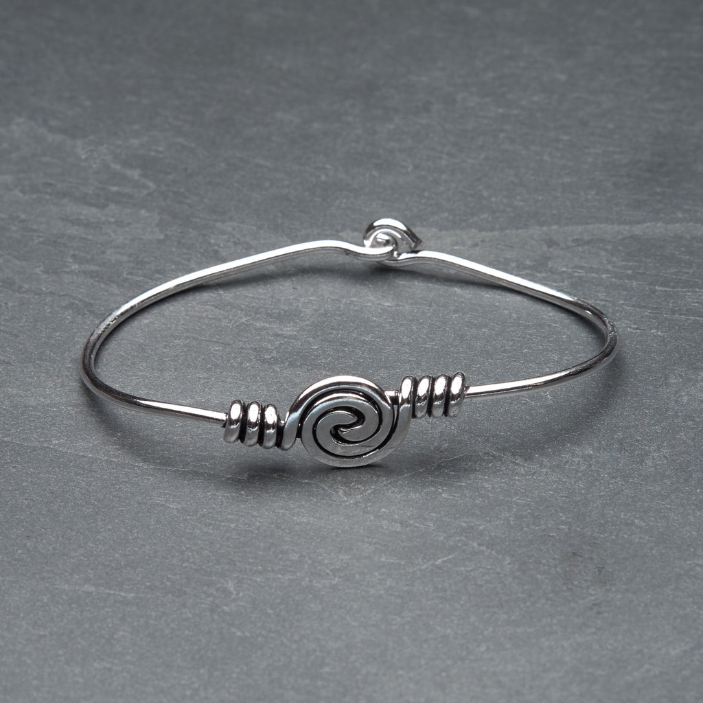A handmade solid silver spiral patterned open bangle designed by OMishka.