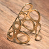 A long, adjustable pure brass, open circle wrap ring designed by OMishka.