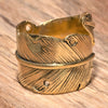 An adjustable, nickel free pure brass, feather wrap ring designed by OMishka.