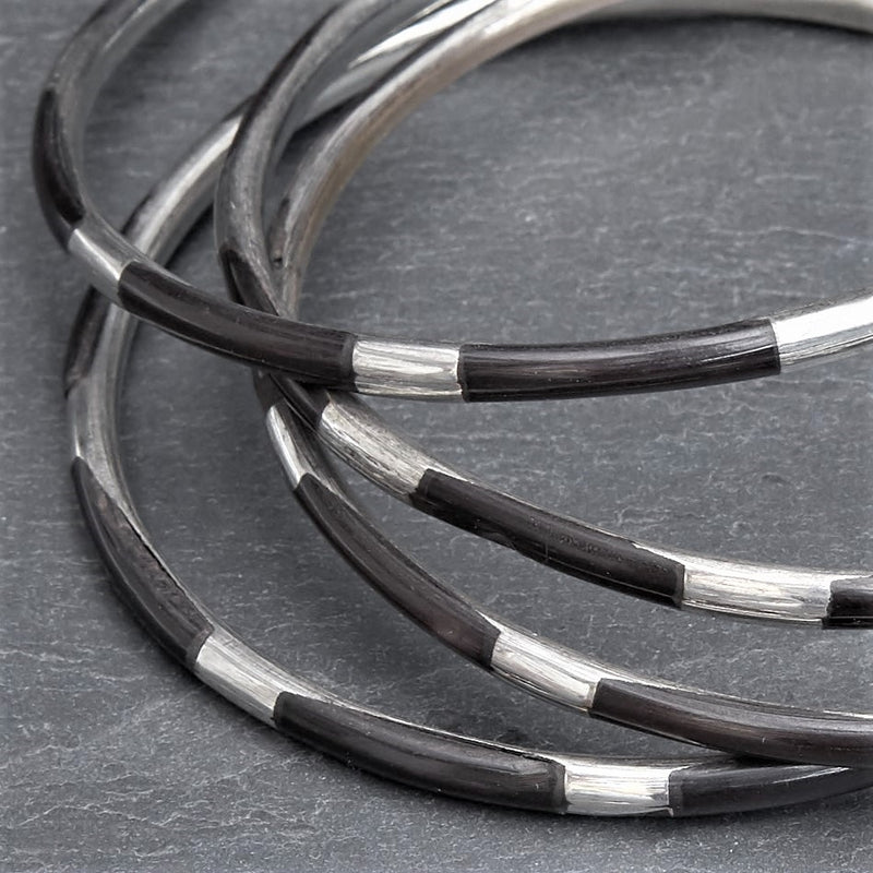 A set of 4 silver and black enamel striped thin bangle bracelets designed by OMishka.