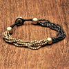 Handmade two tone, golden and oxidised black brass, tiny cube beaded multi strand bracelet designed by OMishka.