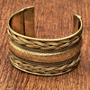 A wide artisan handmade pure brass, woven patterned cuff bracelet designed by OMishka.