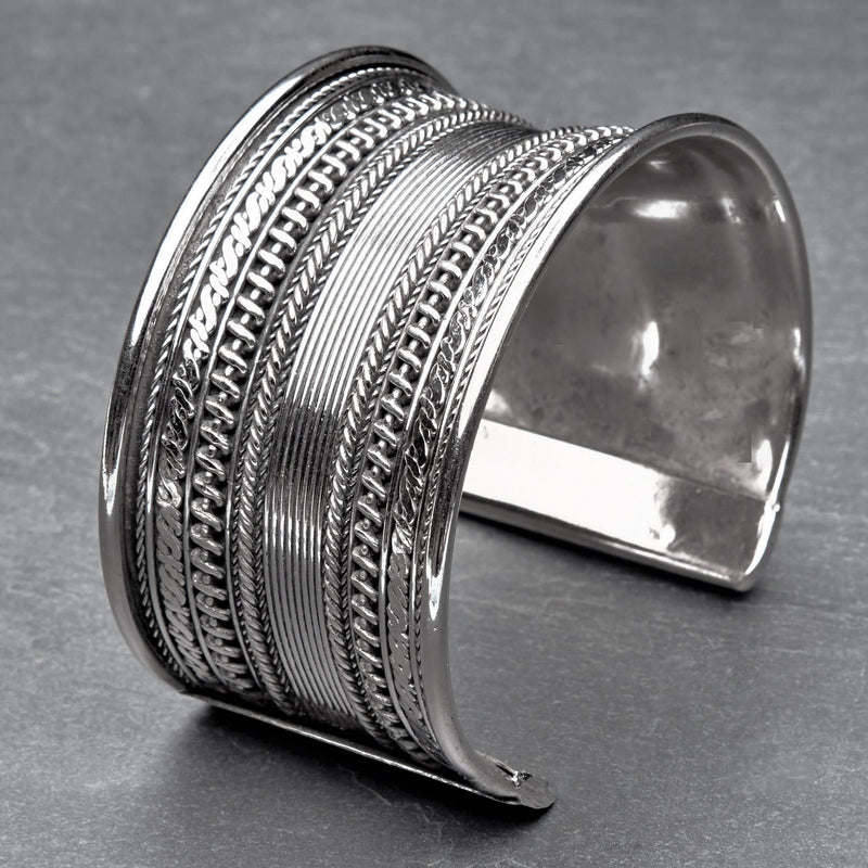 A wide concave, striped patterned silver cuff bracelet designed by OMishka.